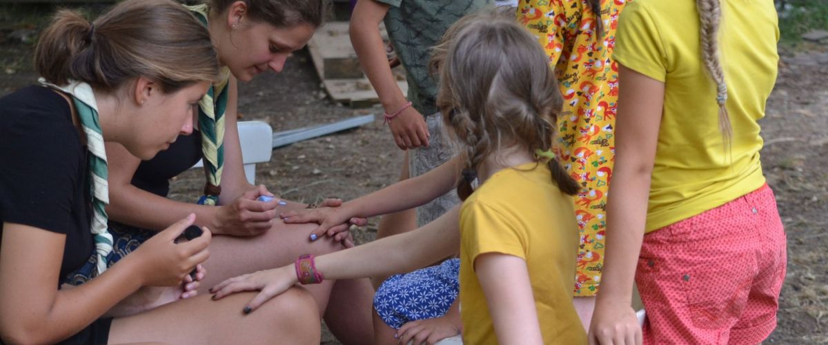 Twee leidsters die de nagels van hun leden lakken.