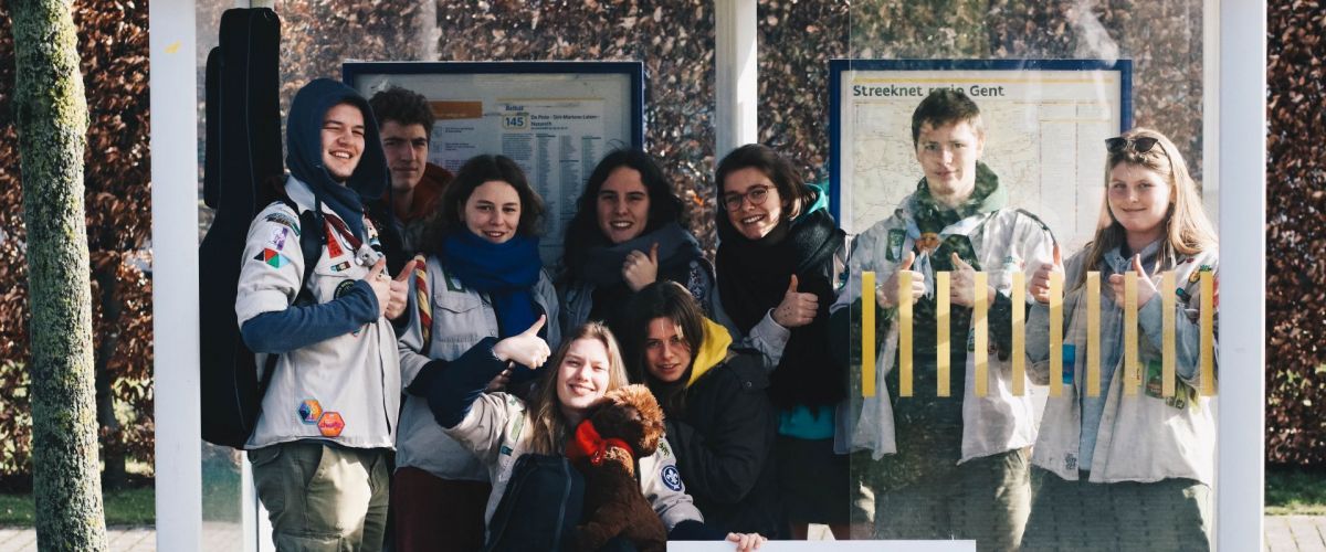 Een groep leiding, eentje in een rolstoel, vult een bushok en poseert, duim omhoog, met het Jintrobord.