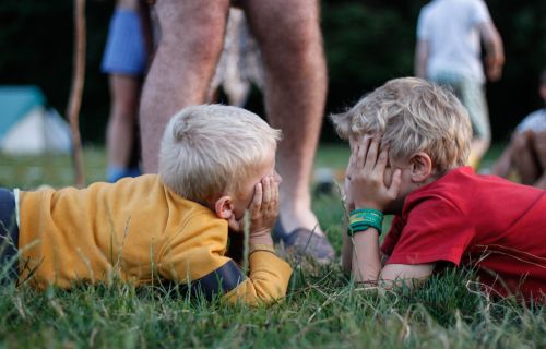 Twee kapoenen liggen tegenover elkaar met de handen voor de ogen