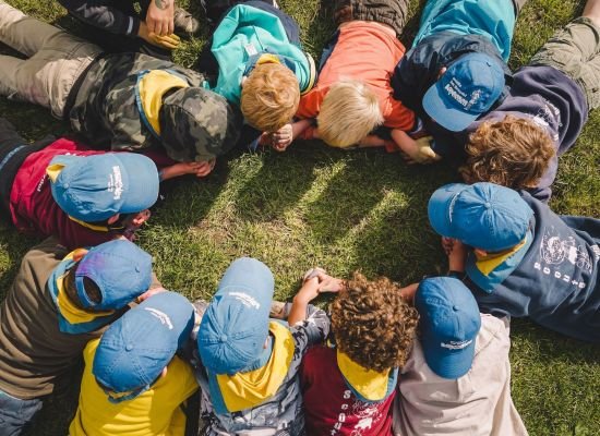 Groep leden liggen allemaal op hun buik in een grote kring