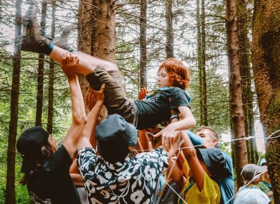 Een groep leiders draagt een jonggiver op hun handen